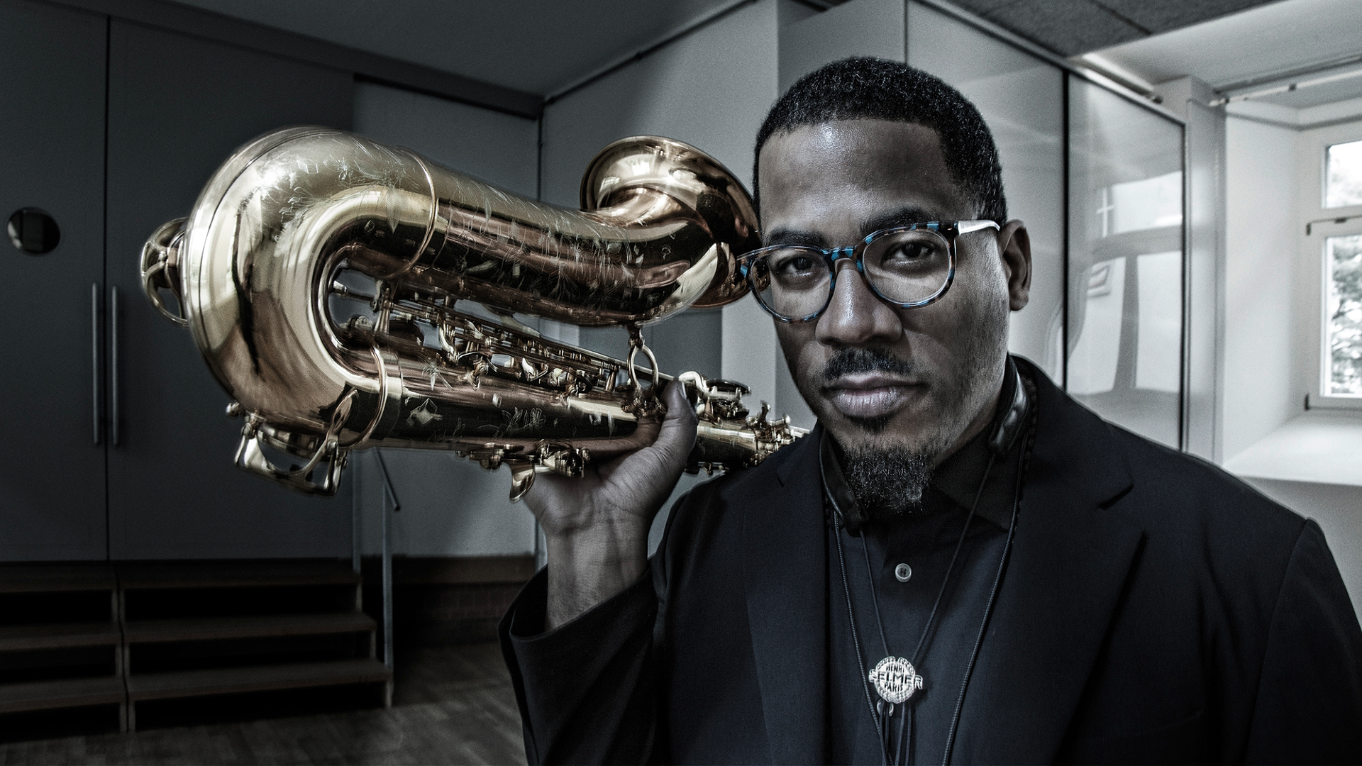 James Brandon Lewis holding a saxophone.