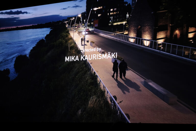 Text "directed by Mika Kaurismäki" on the screen.