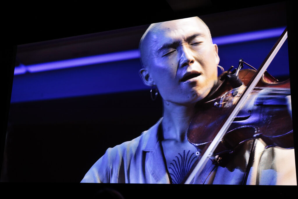 Viulisti soittaa valkokankaalla. Viulisti soittaa valkokankaalla.