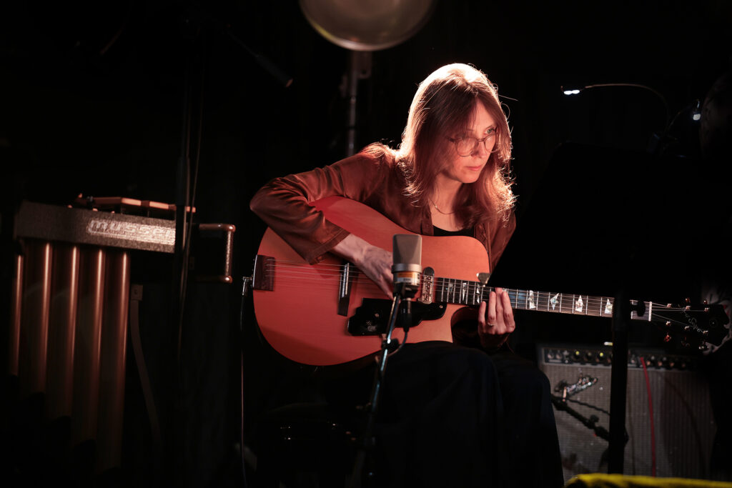 Mary Halvorson is playing the guitar.