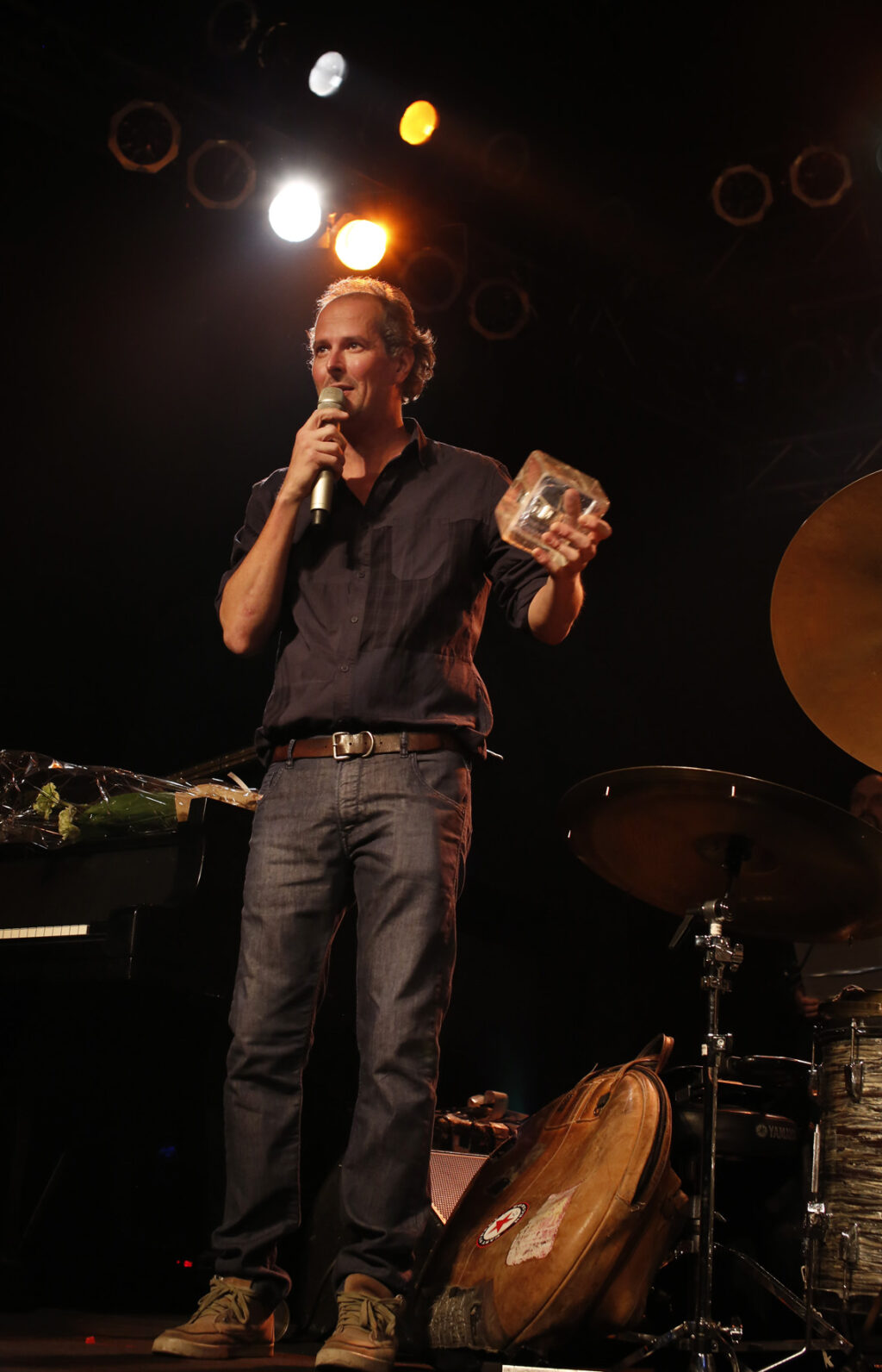 Markku Ounaskari pitää lavalla puhetta Yrjö-palkintoteos kädessään.