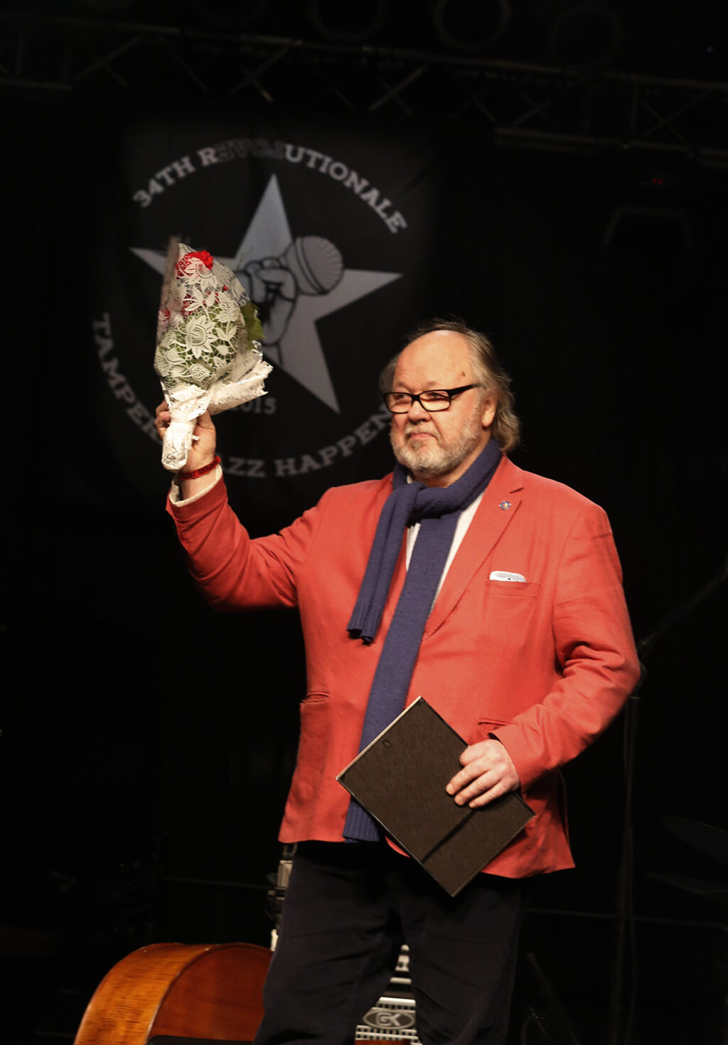 Seppo Hanste lavalla kukkakimppu kädessään.