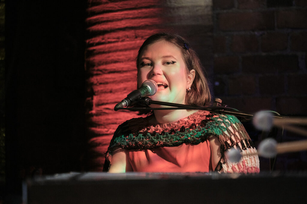 Helmi Antila is playing the piano and singing.