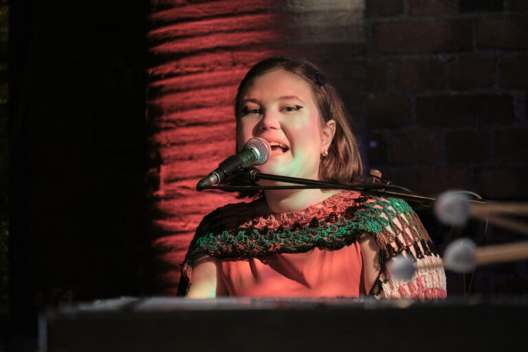 Helmi Antila is playing the piano and singing.