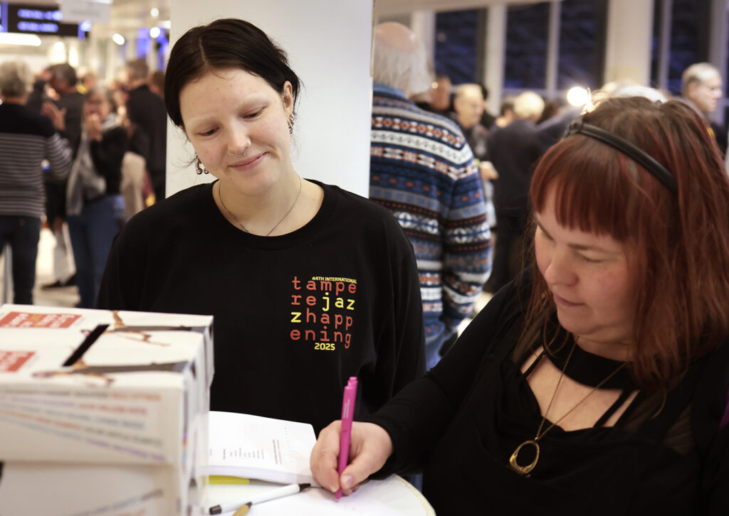 Asiakas täyttää kävijäkyselylomaketta festivaalilla.