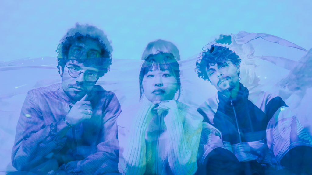 Neon River -yhtyeen promokuva, jossa kolme jäsentä poseeraa sinisävyisessä, kerroksellisessa valotehosteessa.