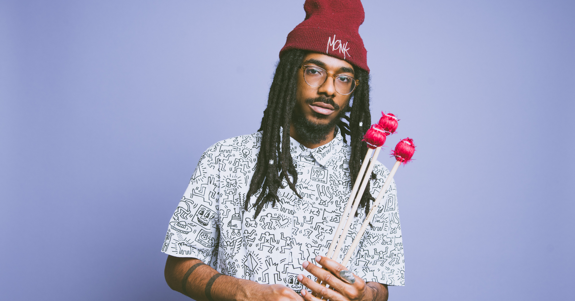 Joel Ross holding vibraphone mallets against a light background.